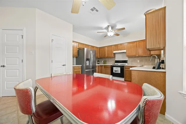 a kitchen with granite countertop a refrigerator stove top oven and sink