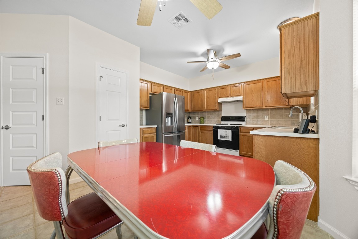 803 North Myrtle Street Georgetown, TX 78626 - Photo 12 of 40 Kitchen featuring gas range oven, stainless steel fridge with ice dispenser, ceiling fan, and under cabinet range hood