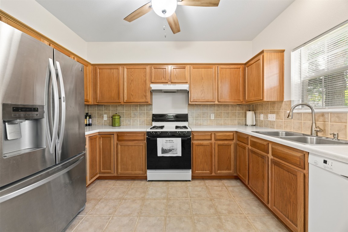 803 North Myrtle Street Georgetown, TX 78626 - Photo 13 of 40 Kitchen featuring stainless steel fridge, dishwasher, range with gas stovetop, under cabinet range hood, and a ceiling fan