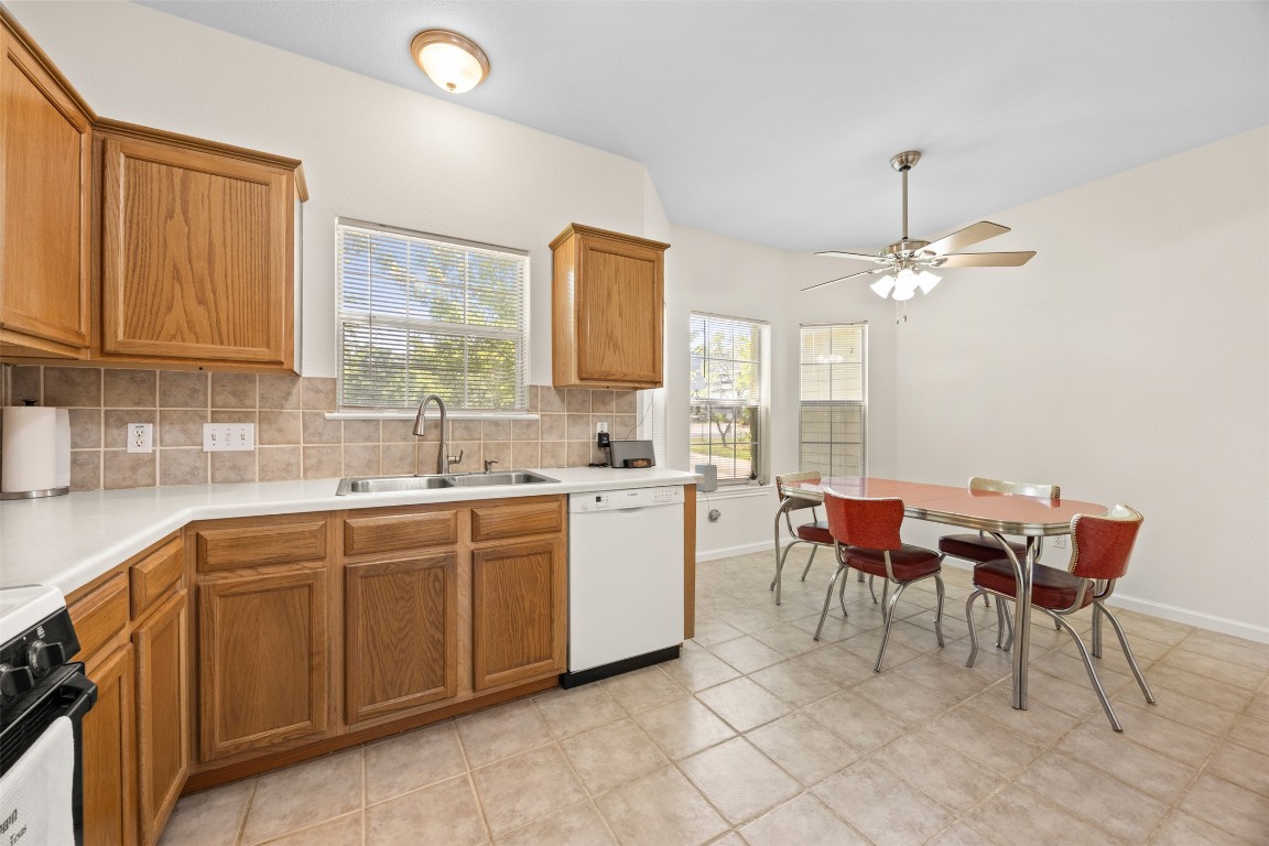 803 North Myrtle Street Georgetown, TX 78626 - Photo 15 of 40 Kitchen featuring white dishwasher, decorative backsplash, stove, and brown cabinetry