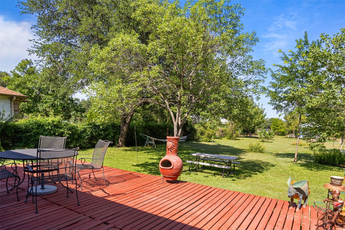 803 North Myrtle Street Georgetown, TX 78626 - Photo 32 of 40 Deck with outdoor dining space, a lawn, and view of scattered trees