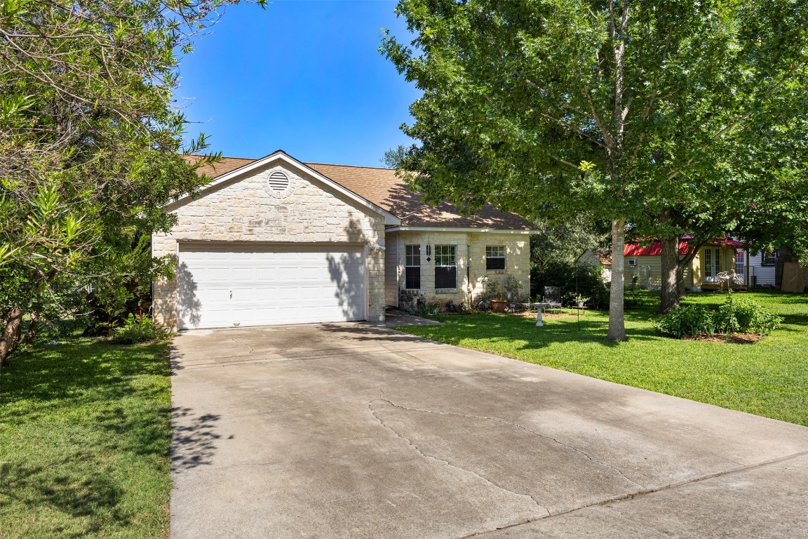 803 North Myrtle Street Georgetown, TX 78626 - Photo 5 of 40 View of front of property with stone siding, a front yard, a garage, and concrete driveway