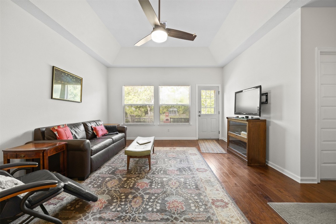 803 North Myrtle Street Georgetown, TX 78626 - Photo 8 of 40 Living room featuring ceiling fan, wood finished floors, and a tray ceiling