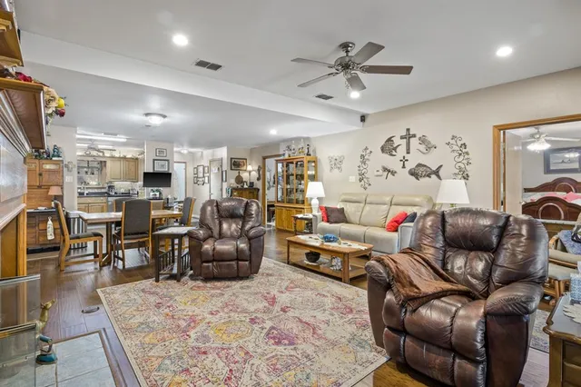 a living room with furniture kitchen view and a chandelier