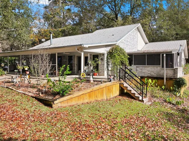 a view of a house with backyard and sitting area
