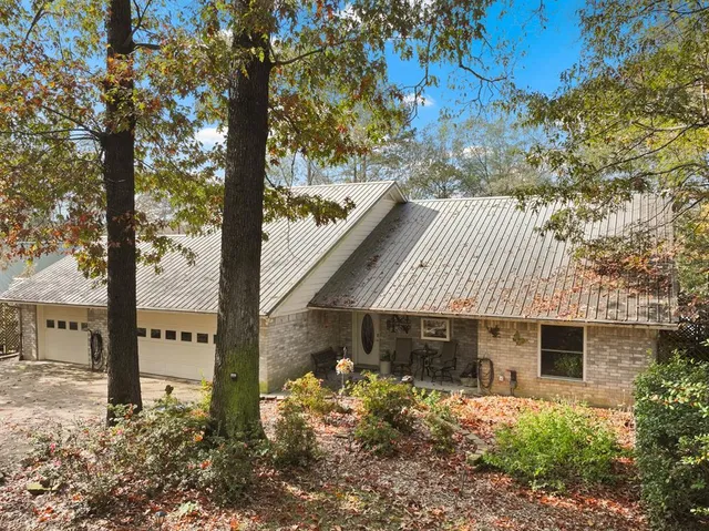 a front view of a house with a tree