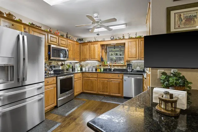a kitchen with stainless steel appliances granite countertop a refrigerator sink and stove