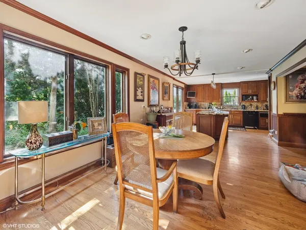 a dining room with furniture a chandelier and wooden floor
