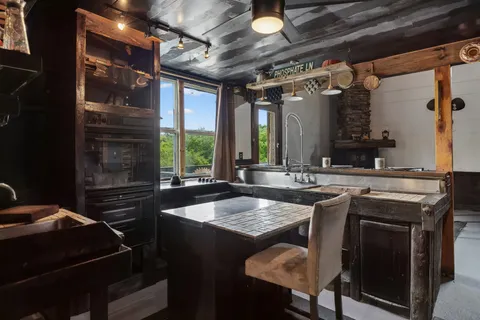 a kitchen with a sink and chairs