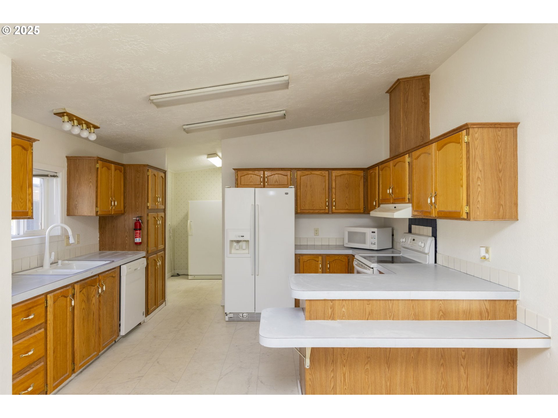 1949 Southeast Palmquist Road, Unit 80 Gresham, OR 97080 - Photo 14 of 35 a kitchen with a refrigerator sink and a wooden cabinets