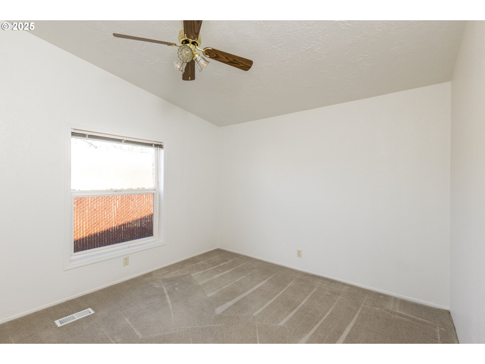 1949 Southeast Palmquist Road, Unit 80 Gresham, OR 97080 - Photo 21 of 35 an empty room with a window and a ceiling fan