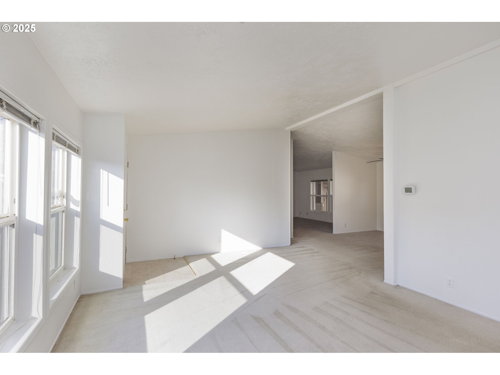 1949 Southeast Palmquist Road, Unit 80 Gresham, OR 97080 - Photo 5 of 35 a view of an empty room with wooden floor and a window