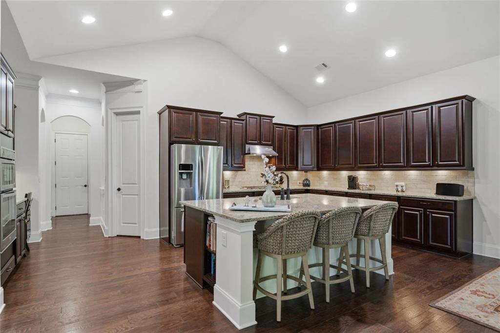 12115 Spence Way Alpharetta, GA 30004 - Photo 27 of 46 a kitchen with kitchen island granite countertop wooden cabinets and stainless steel appliances