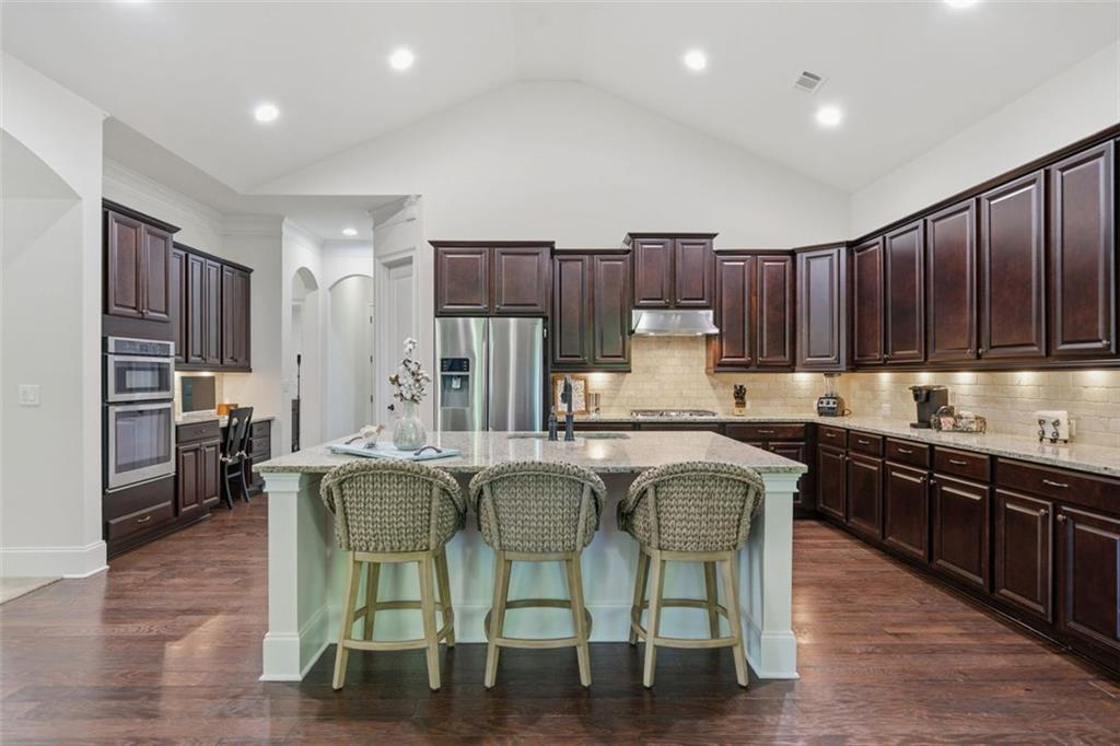 12115 Spence Way Alpharetta, GA 30004 - Photo 28 of 46 a kitchen with stainless steel appliances granite countertop wooden cabinets a refrigerator a stove a sink and a chairs