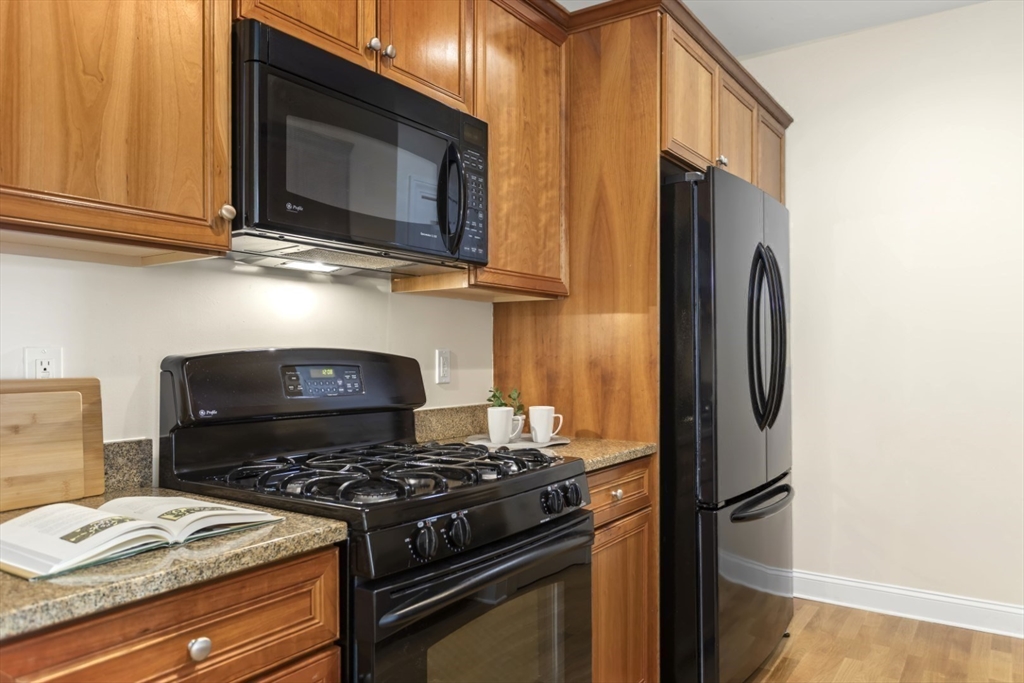 248 Albion Street, Unit 233 Wakefield, MA 01880 - Photo 17 of 39 a kitchen with stainless steel appliances granite countertop a stove and a refrigerator