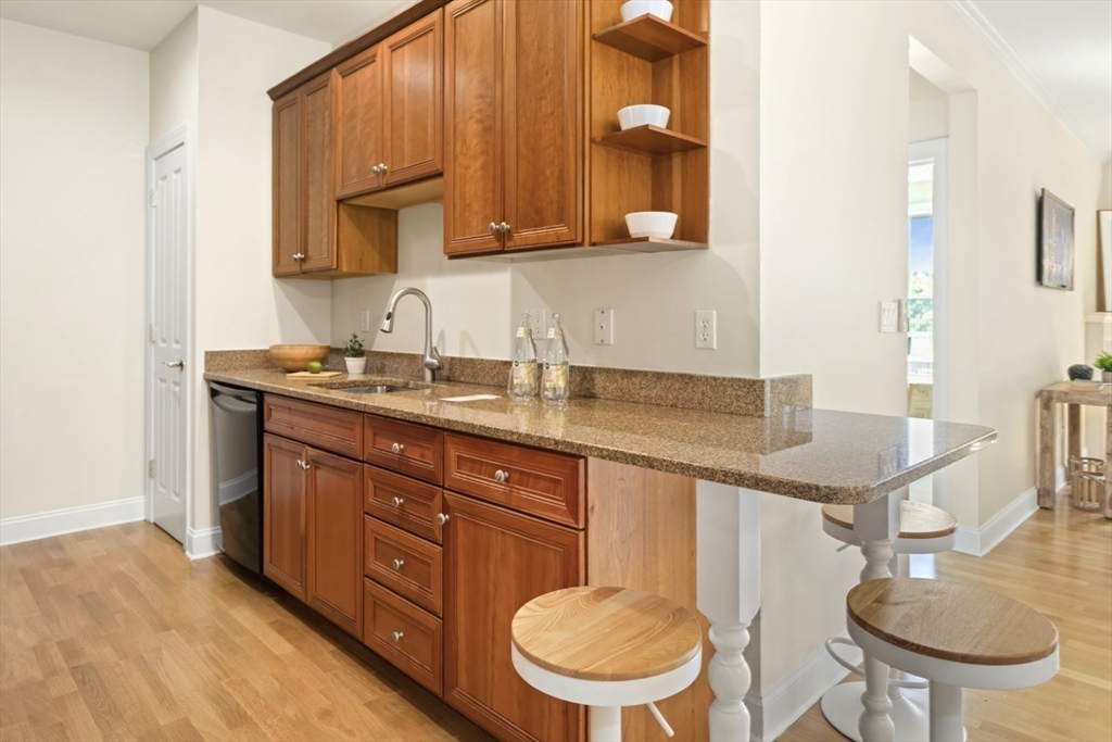 248 Albion Street, Unit 233 Wakefield, MA 01880 - Photo 21 of 39 a bathroom with a granite countertop toilet a sink and a mirror