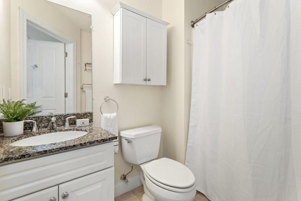 248 Albion Street, Unit 233 Wakefield, MA 01880 - Photo 33 of 39 a bathroom with a granite countertop sink mirror vanity and toilet
