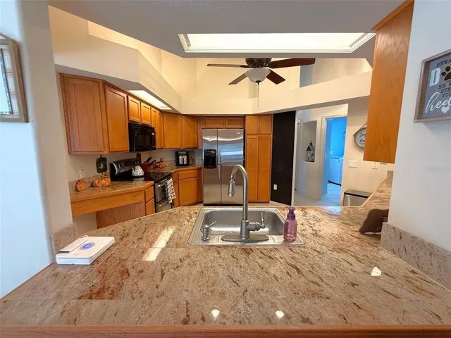 a kitchen with stainless steel appliances kitchen island granite countertop a sink and cabinets