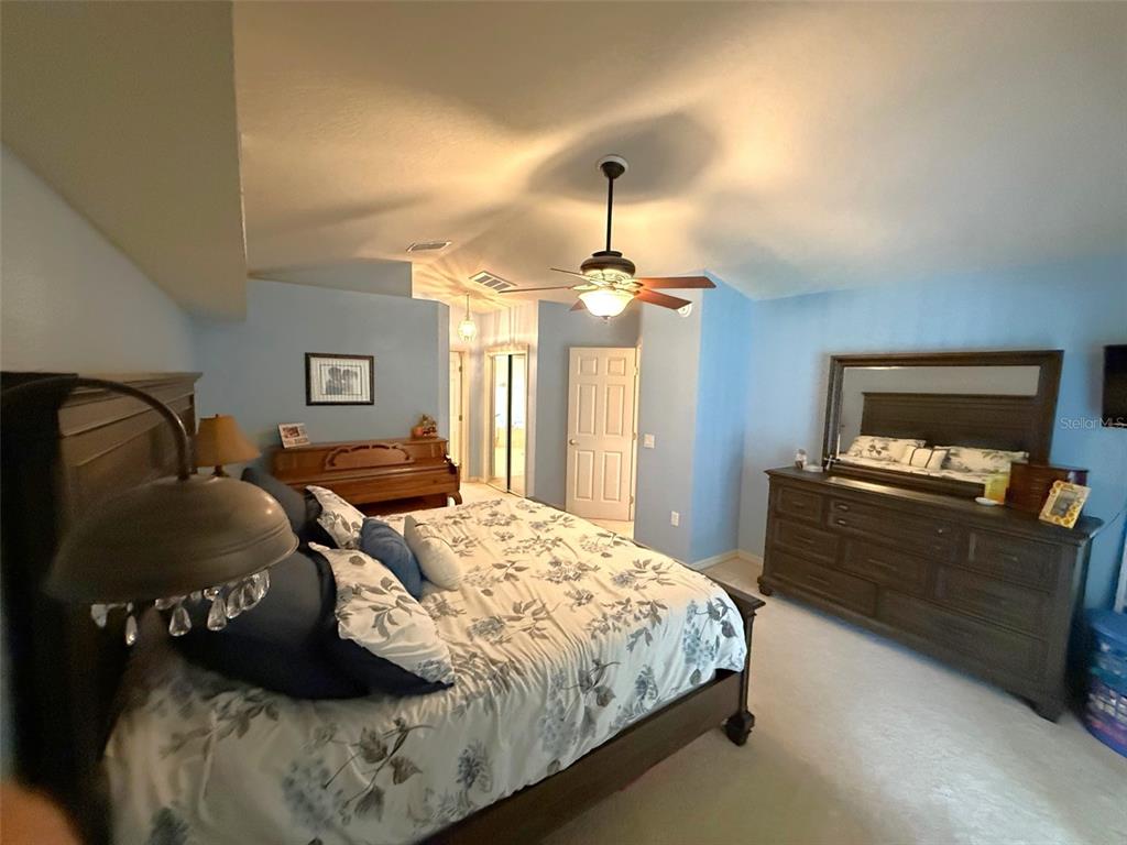 4980 Southeast 47th Terrace Road Ocala, FL 34480 - Photo 23 of 54 a bedroom with a bed and a chandelier