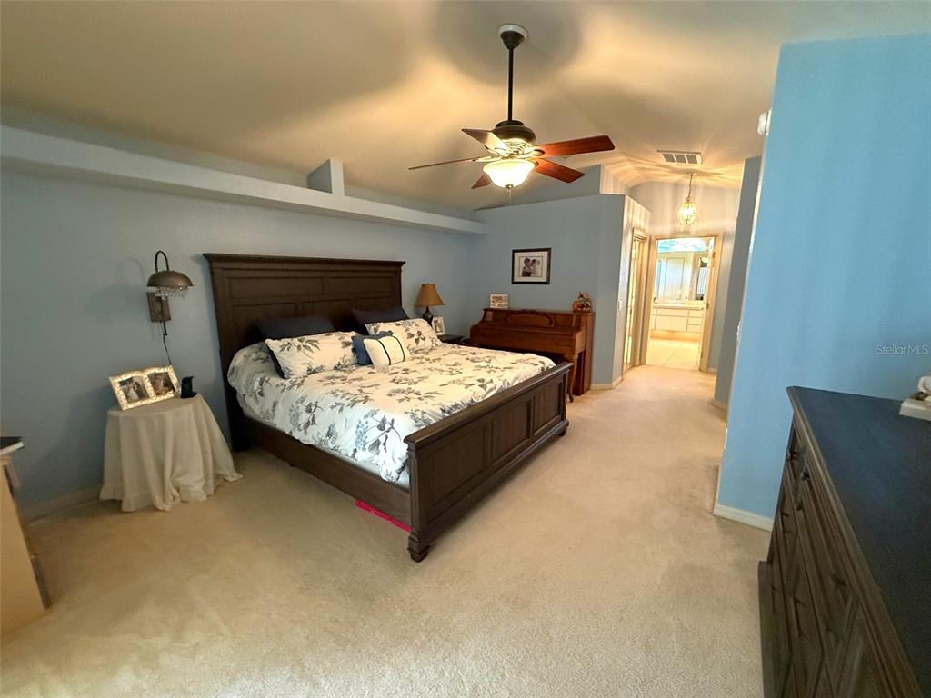 4980 Southeast 47th Terrace Road Ocala, FL 34480 - Photo 24 of 54 a bedroom with a bed and a chandelier