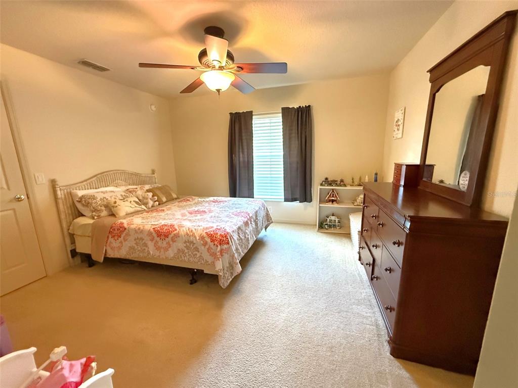 4980 Southeast 47th Terrace Road Ocala, FL 34480 - Photo 31 of 54 a bedroom with a bed and a chandelier