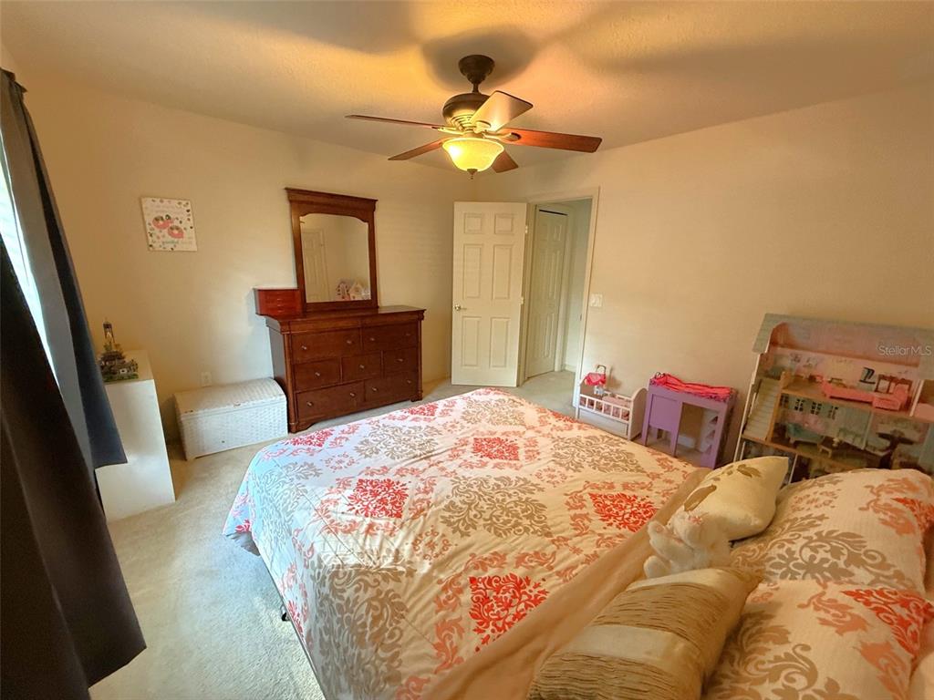 4980 Southeast 47th Terrace Road Ocala, FL 34480 - Photo 32 of 54 a bedroom with a bed and a chandelier