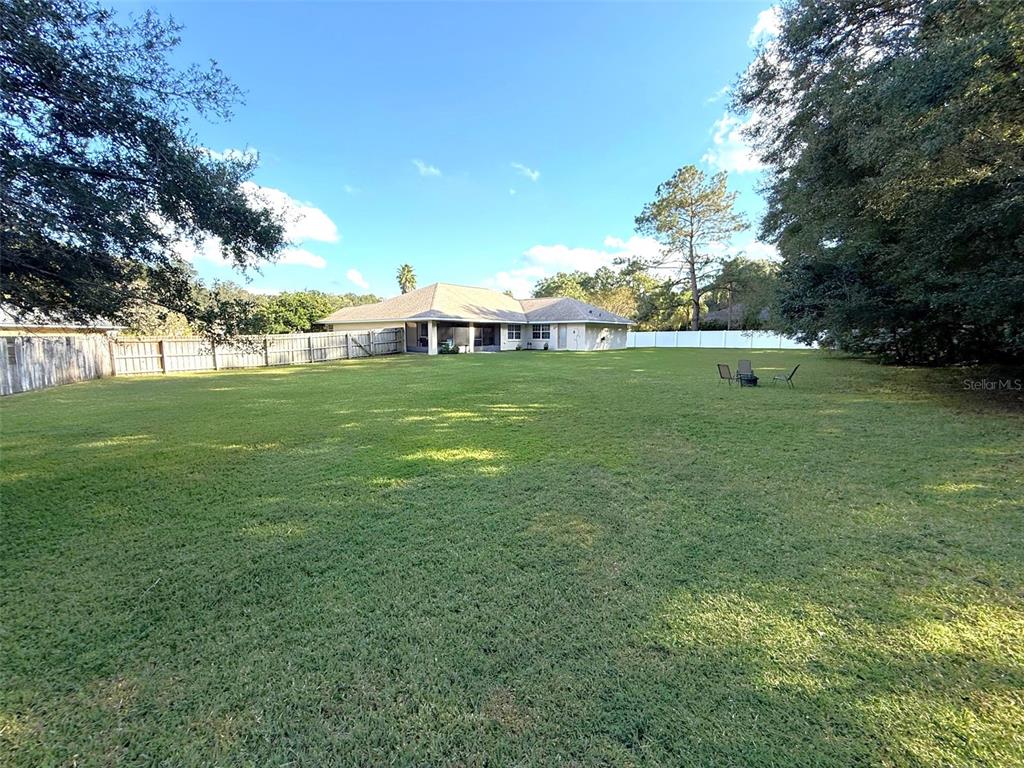 4980 Southeast 47th Terrace Road Ocala, FL 34480 - Photo 39 of 54 a backyard of a house with lots of green space