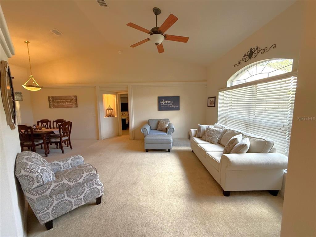 4980 Southeast 47th Terrace Road Ocala, FL 34480 - Photo 7 of 54 a living room with furniture and a chandelier