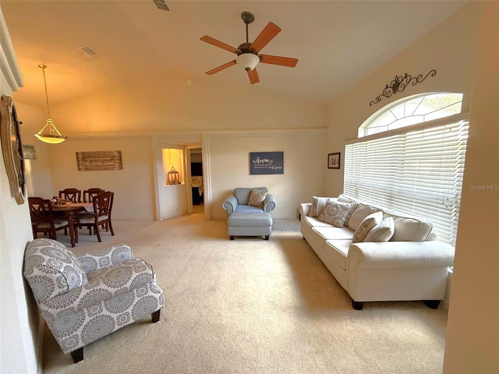 4980 Southeast 47th Terrace Road Ocala, FL 34480 - Photo 8 of 54 a living room with furniture and a chandelier