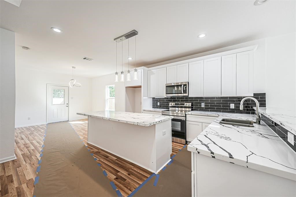 5317 Chennault Road, Unit A Houston, TX 77033 - Photo 7 of 11 a kitchen with a stove a sink and a refrigerator