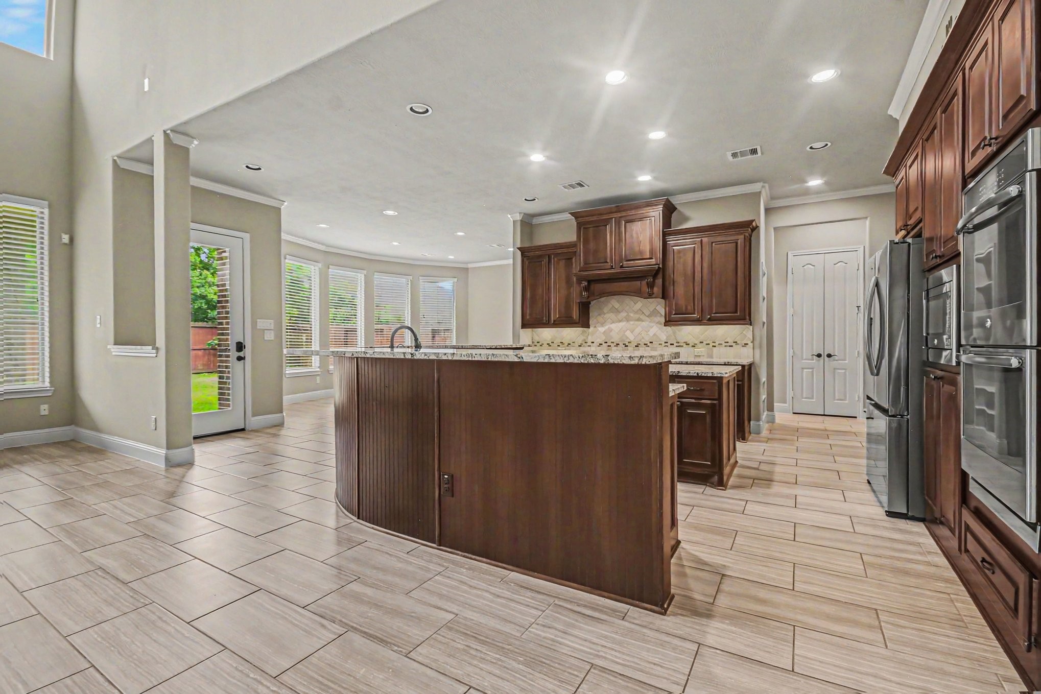 3310 Ralston Edge Lane Houston, TX 77059 - Photo 15 of 50 a kitchen with stainless steel appliances kitchen island granite countertop a refrigerator a stove and a sink
