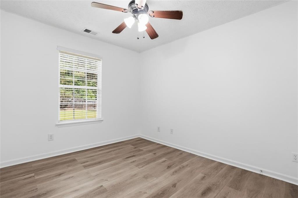 640 Howell Drive Locust Grove, GA 30248 - Photo 14 of 41 an empty room with wooden floor fan and windows