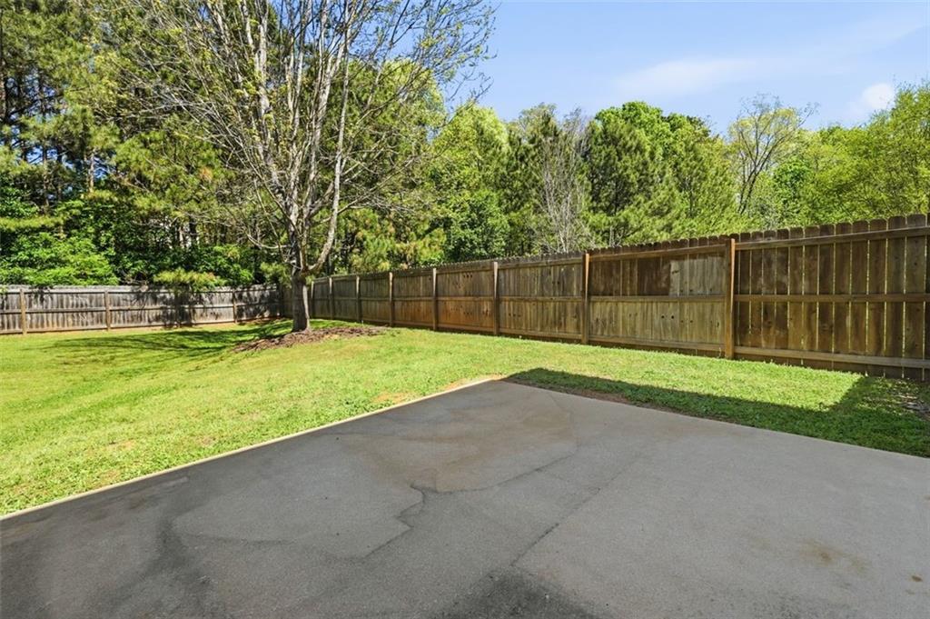 640 Howell Drive Locust Grove, GA 30248 - Photo 29 of 41 a view of a backyard with large trees and wooden fence