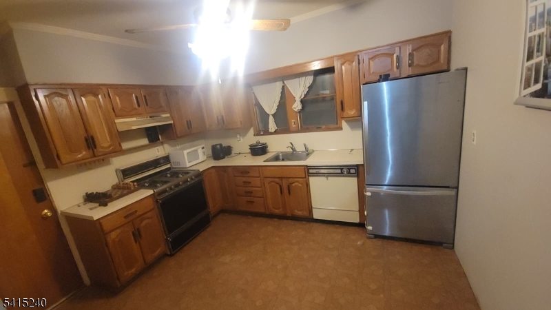 116 Elmora Avenue Elizabeth, NJ 07202 - Photo 2 of 5 a kitchen with stainless steel appliances granite countertop a refrigerator a stove a sink and a refrigerator with wooden floor