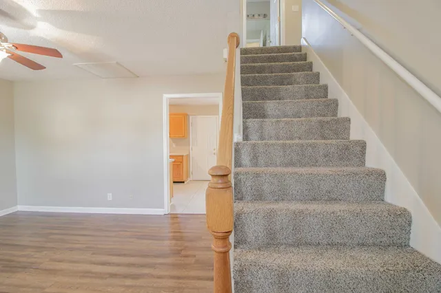 a view of staircase with white walls and door