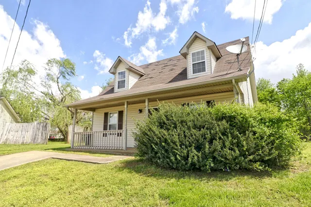 a view of an house with backyard and trees
