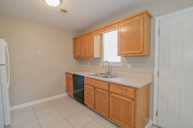 a kitchen with stainless steel appliances granite countertop a sink and dishwasher with white cabinets
