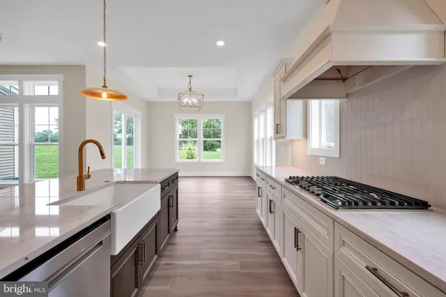 a kitchen with kitchen island a counter space a sink a window and stainless steel appliances