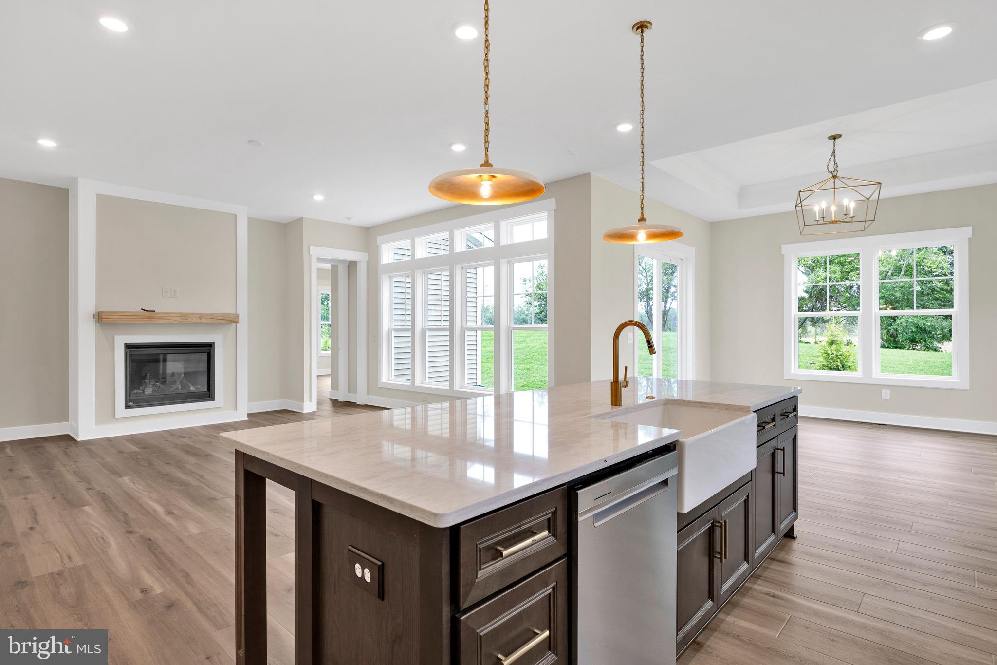 23412 East Gate Drive Frankford, DE 19945 - Photo 12 of 28 a kitchen with granite countertop a stove a sink a center island and wooden floor