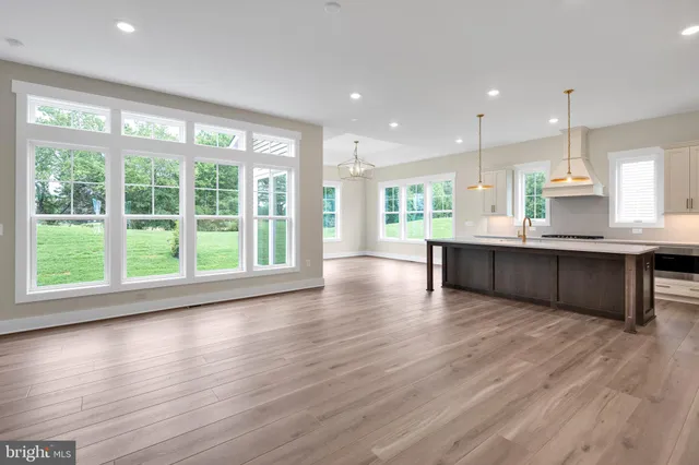 a large kitchen with large windows and wooden floor