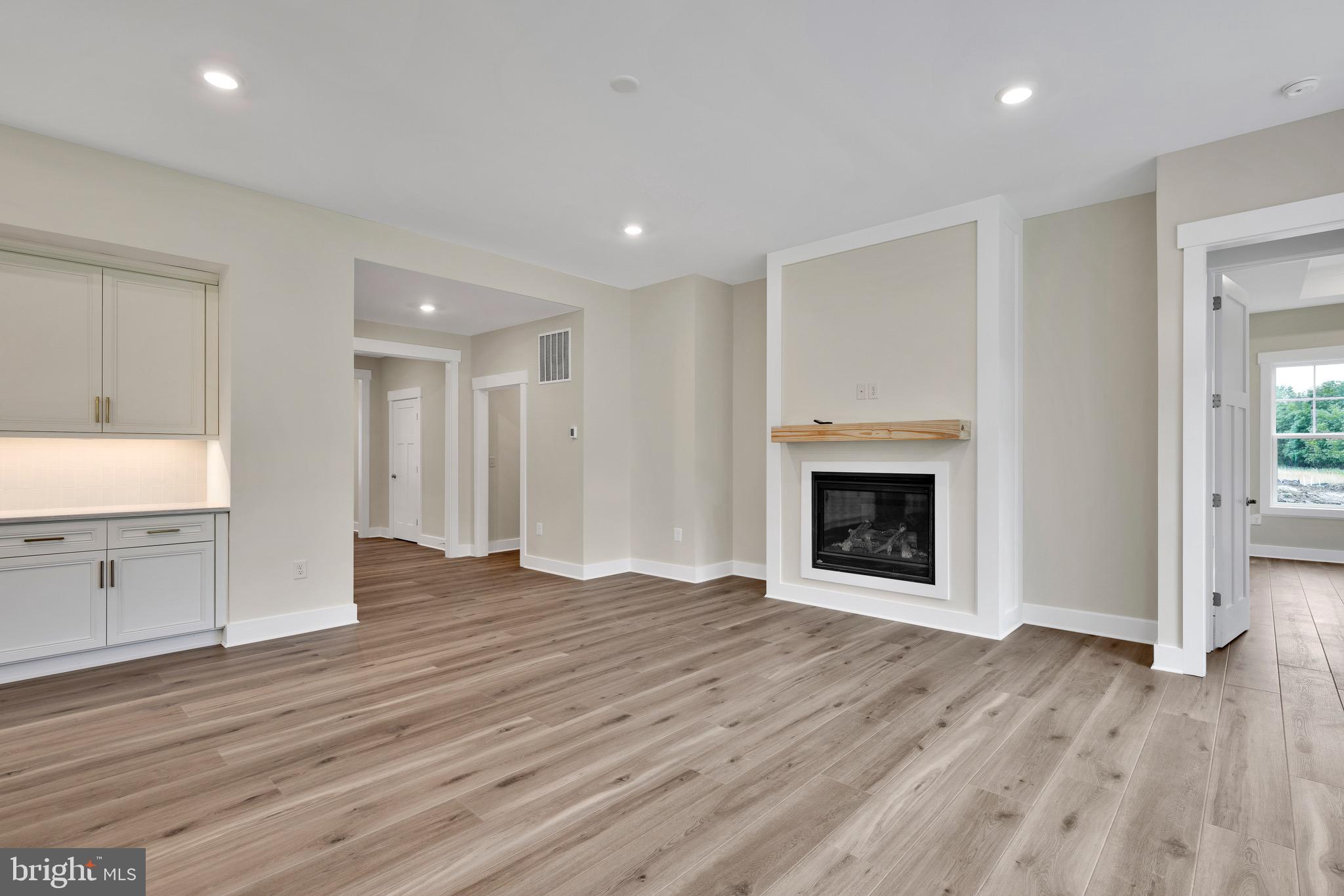 23412 East Gate Drive Frankford, DE 19945 - Photo 18 of 28 a view of an empty room with wooden floor fireplace and a window