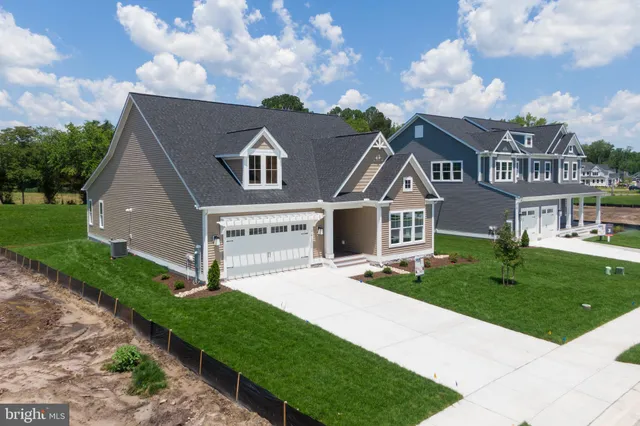 a front view of a house with a garden and yard