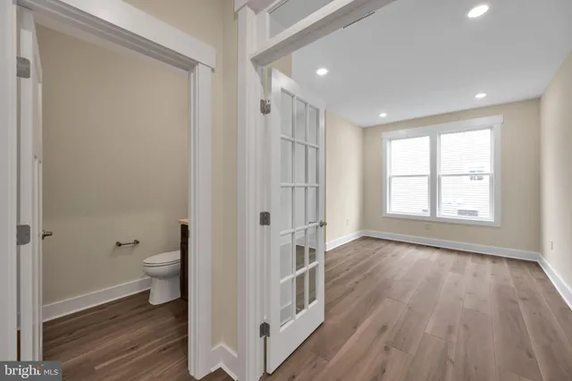 a bathroom with a toilet a sink and a large mirror