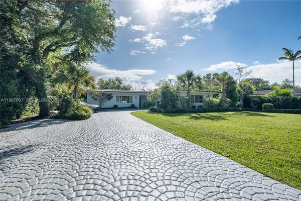a view of backyard with swimming pool and green space