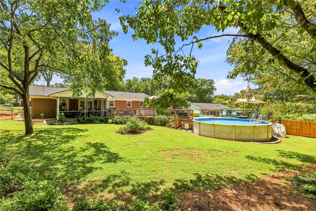 204 Sylvia Road Easley, SC 29642 - Photo 32 of 36 A spacious backyard oasis features an inviting above-ground pool, expansive lawn, and a charming screened porch.