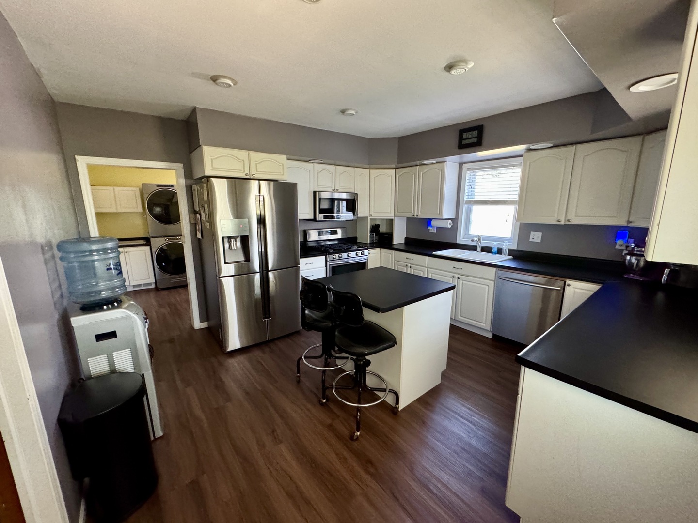 301 West Jackson Street Ohio, IL 61349 - Photo 17 of 32 a kitchen with stainless steel appliances granite countertop a refrigerator a sink dishwasher a stove top oven a dining table and chairs with wooden floor