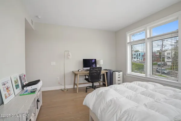 a bedroom with a bed and a computer on the desk