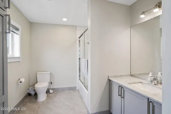 a bathroom with a toilet sink and mirror