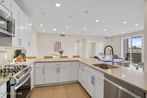 a kitchen with white cabinets appliances and a sink