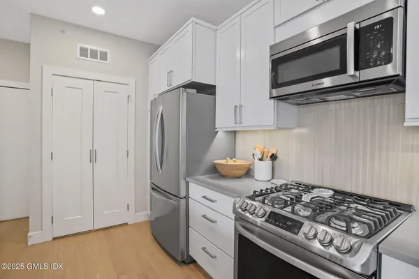 a kitchen with stainless steel appliances a stove a microwave and cabinets
